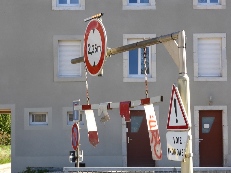 Panneau et portique pour annoncer la hauteur limitée sous le pont de la rue des Jardins, dans le sens descendant