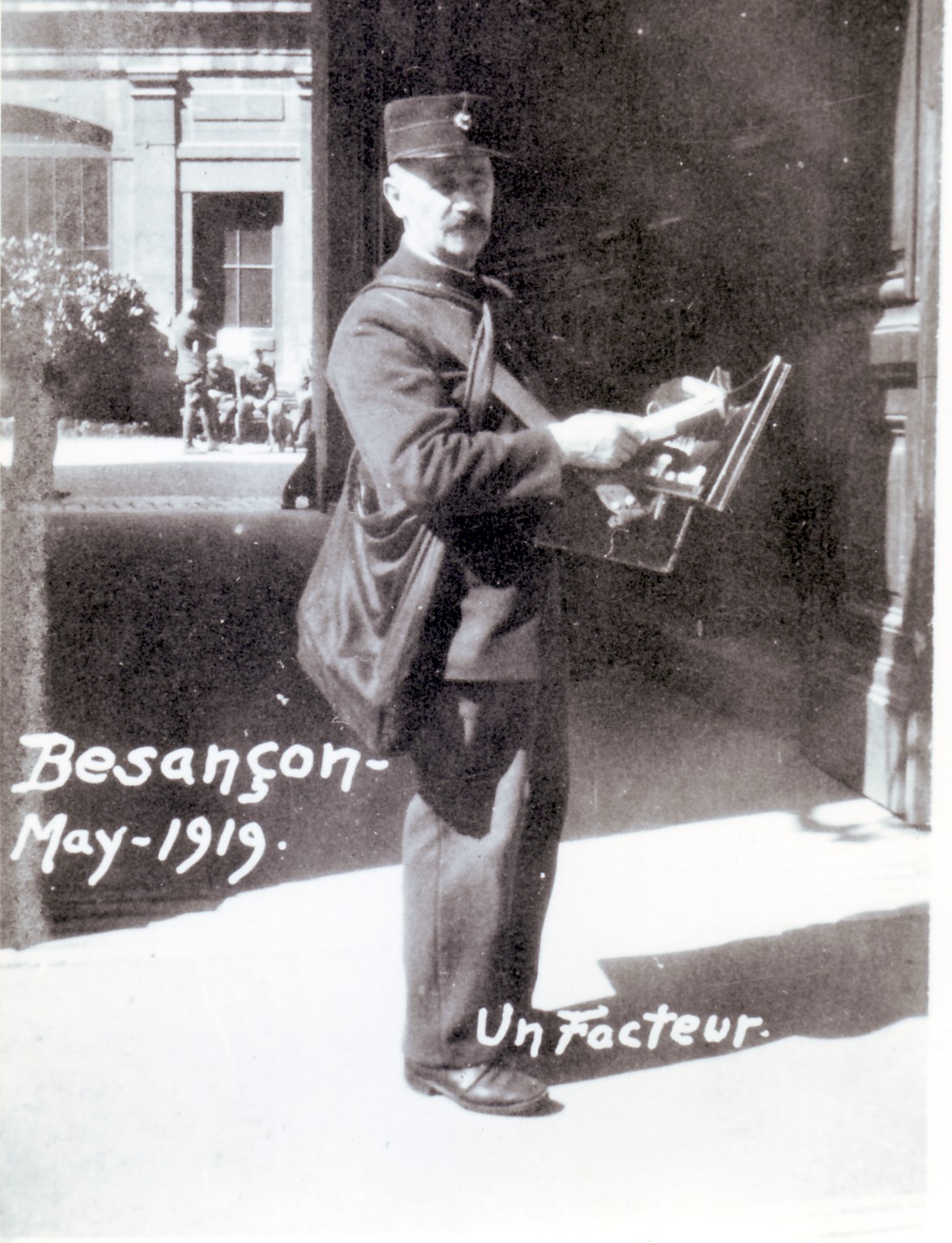 Photo d'un facteur, en mai 1909, dans la Bouclen rue Mégevand, devant entrée de la Faculkté des Lettres. photographie prise par un soldat américain qui saississait tous les anciens métiers bisontins